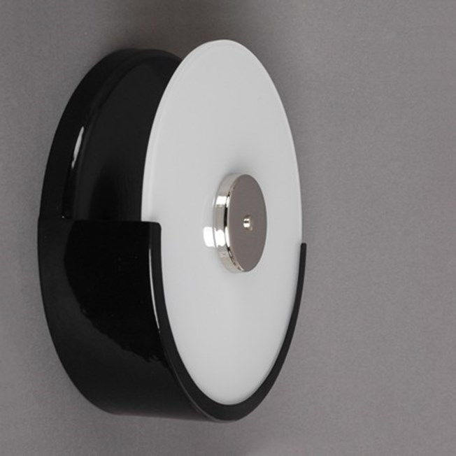 Side view staircase wall lamp with black finish and opal white, round shaped glass.
